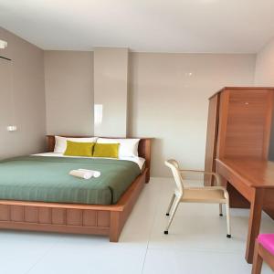 a bedroom with a bed and a desk and a chair at Nuasana Living Dukuh Kupang Barat in Surabaya