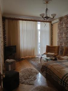 a bedroom with a bed and a couch and a tv at Просторная, двухкомнатная квартира ,с великолепным видом на город, расположенная в центре города Баку in Baku