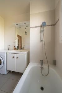 a white bathroom with a bath tub and a sink at Heaven Loft - proche RER A - DISNEY LAND in Bussy-Saint-Georges