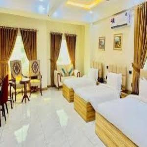 Un dormitorio con dos camas y una mesa y sillas. en Stay Maison, en Rawalpindi