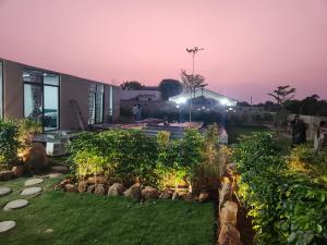 a garden in front of a building at night at Hosh posh villa in Hyderabad