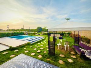 a white tent with chairs and a swimming pool at Hosh posh villa in Hyderabad