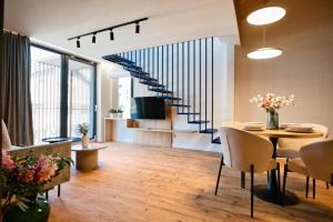 ein Wohnzimmer mit Tisch und Treppe in der Unterkunft Laguna Beskidów Resort - Apartamenty Royal in Zarzecze
