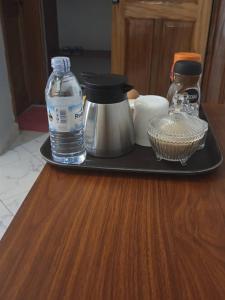 a tray with a coffee maker and a bottle of water at Gibson Motel in Mbarara