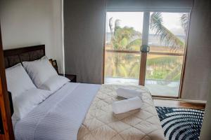 a bedroom with a bed and a large window at Sundowners in Chilaw +25 photos