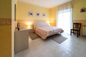 a bedroom with a bed and a chair and a window at Il Noccioleto in Linguaglossa