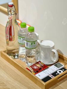 a wooden tray with bottles of water and a remote control at Vân Trang Hotel in Vĩnh Long