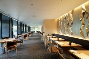 a restaurant with wooden tables and chairs and windows at The Capitol Hotel Tokyu in Tokyo