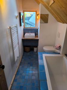 a bathroom with a sink and a toilet and a tub at Ancienne maison de pêcheur à St Cado charme, authenticité et confort in Belz