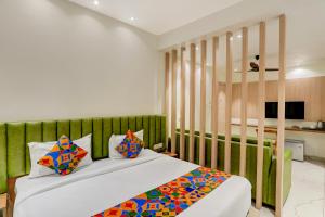 a bedroom with a bed with colorful pillows at FabHotel Silver Cloud in Warangal