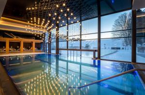 a swimming pool with lights in a building at Wellness & Naturresort Reischlhof in Wegscheid