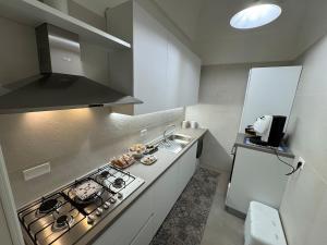 une petite cuisine avec une cuisinière et un évier dans l'établissement Dimora Margherita, à San Michele Salentino