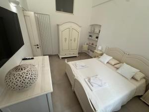 Cette chambre blanche dispose d'un lit, d'une table et d'une table. dans l'établissement Dimora Margherita, à San Michele Salentino