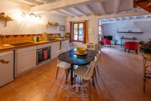 a kitchen with a table and chairs in a room at Mas Sant Jordi in Alénya