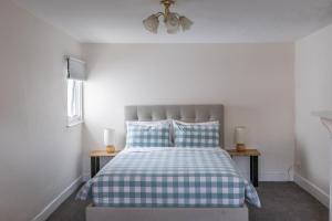 a bedroom with a bed with blue and white checked sheets at 128 Murray - Sassafras in Hobart