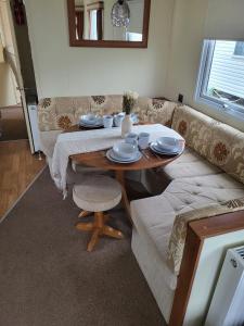 a living room with a table and a couch at Caravan by the Sea 640 in Kinmel Bay