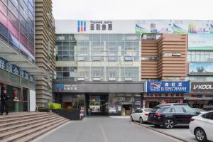 un grand bâtiment avec des voitures garées devant dans l'établissement Tianhe Residence, Shanghai, à Shanghai