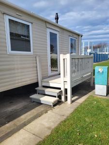 a mobile home with a porch and a staircase at Caravan by the Sea 640 in Kinmel Bay