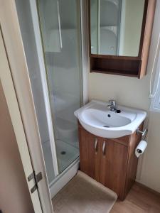 a bathroom with a sink and a shower at Caravan by the Sea 640 in Kinmel Bay +12 photos