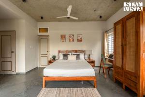 a bedroom with a bed and a ceiling fan at StayVista at Villa Atharva Anekal Bengaluru in Bengaluru