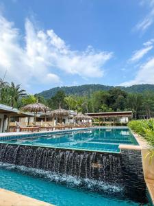 een zwembad met waterval voor een resort bij The Palm Villa in Ban Ai Dao