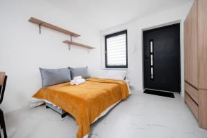 a bedroom with a bed and a black door at Łódź Urban Serenity Studio #10 by BookingHost in Łódź