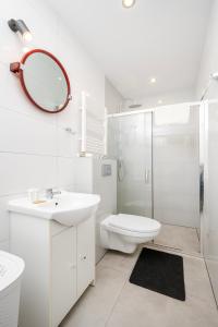 a bathroom with a sink toilet and a mirror at Łódź Urban Serenity Studio #10 by BookingHost in Łódź