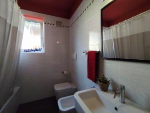 Un baño con lavabo, inodoro y espejo. en Comfort on the Mountain Side by Holiday World, en Piovene Rocchette 16 fotos más