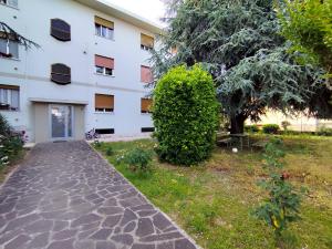 een gebouw met een boom en een loopbrug bij Comfort on the Mountain Side by Holiday World in Piovene Rocchette