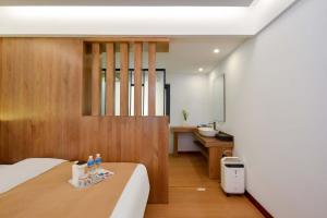 a bedroom with a bed and a bathroom with a sink at Da Le Zhi Ye Homestay in Shangri-La