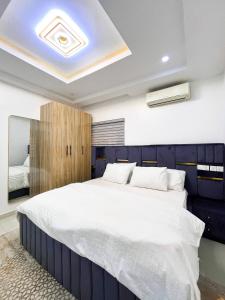 a bedroom with a large bed with a blue headboard at Luxurious 3BR Apartment 247 Power City views in Kadobunkuro