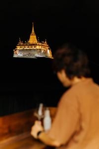 a woman sitting at a table with a cruise ship in the background at Samranscape in Bangkok