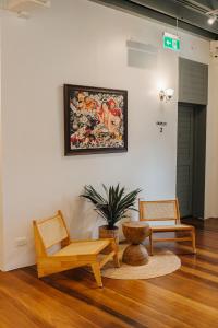 a living room with two chairs and a painting on the wall at Samranscape in Bangkok +5 photos