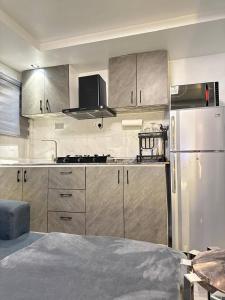 a kitchen with stainless steel appliances and a refrigerator at Luxurious Abuja Apartment with Private Entrance Central AC in Garki +2 photos