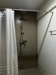 a shower in a bathroom with a shower curtain at Luxurious Abuja Apartment with Private Entrance Central AC in Garki