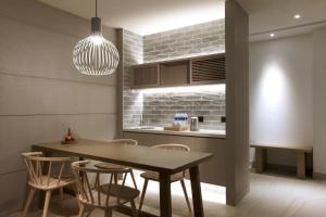 une salle à manger avec une table et des chaises et une cuisine dans l'établissement Discovery Hotel, à Magong