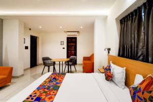 ハイデラバードにあるFabHotel Casa Grandのベッドとテーブルと椅子のあるホテルの部屋