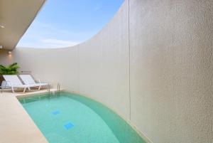 a swimming pool in a building with a window at Centara Karon Villas Phuket in Karon Beach