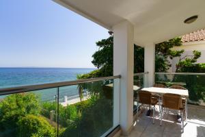 a balcony with a table and chairs and the ocean at Porto Iliessa in Argasi +24 photos