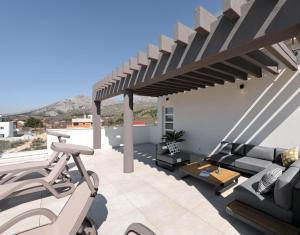 Un patio con un sofá y un banco y una pérgola. en Villa Stanic, en Seline