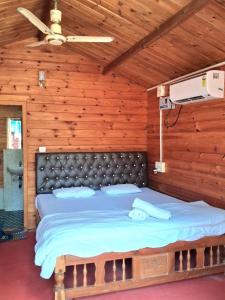 Un dormitorio con una cama grande en una pared de madera. en Brendons Goa, en Palolem 27 fotos más