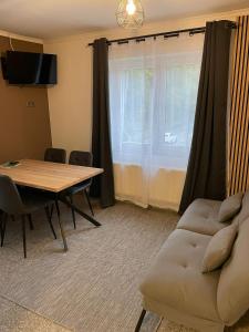 a living room with a table and a couch at LetzCamp Mullerthal Apartments in Grundhof +14 photos