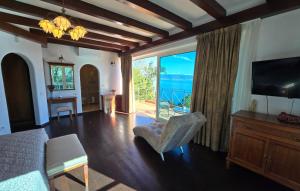 a bedroom with a bed and a television and a balcony at Villa Palazzo del mar Opatija by Villas Guide in Mošćenička Draga