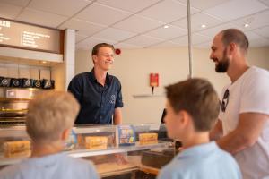 a group of children standing in a kitchen talking to a chef at Resort Veluwe in Garderen +24 photos