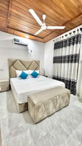una camera da letto con un letto grande con cuscini blu di Apartment W Kitchen 5 Mins Beach 20 Mins Airport a Negombo