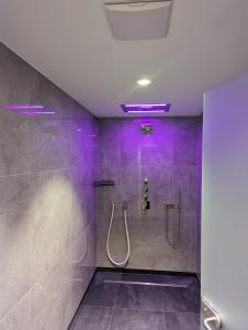 baño con ducha con iluminación púrpura en Gästehaus Lemerhof, en Oberding