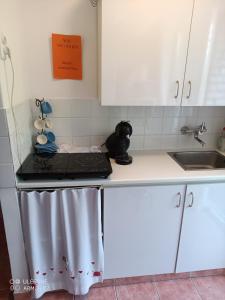 a kitchen with white cabinets and a stove and a sink at Krisztina apartman in Balatonfüred