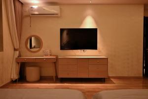 a living room with a tv on a wall at Shushushe B&B in Jiawan