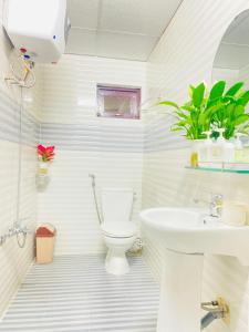 a white bathroom with a toilet and a sink at Dona Hotel in Da Lat +19 photos