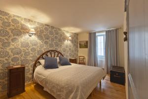 a bedroom with a bed with blue and white sheets at Les Logis du Théâtre in Poligny
